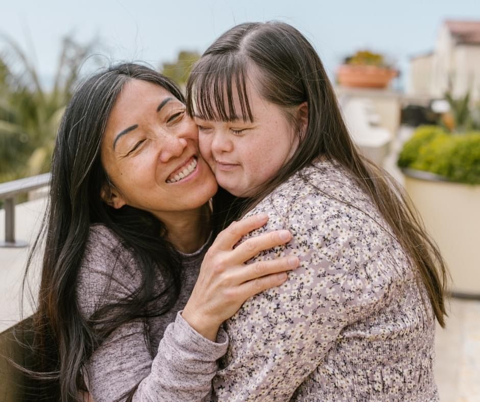 A smiling mother hugging her adult daughter
